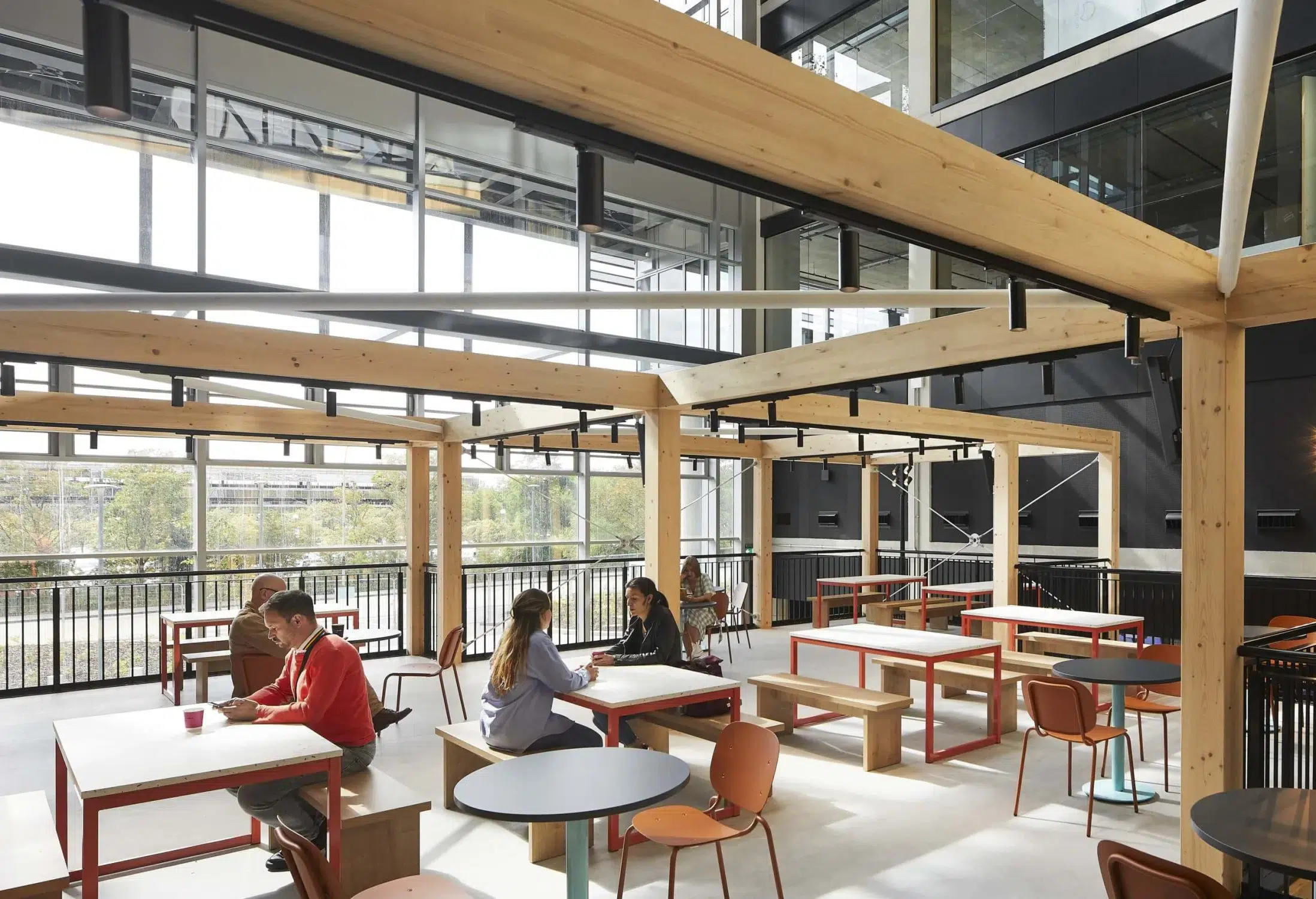 people sitting at wooden tables inside a building